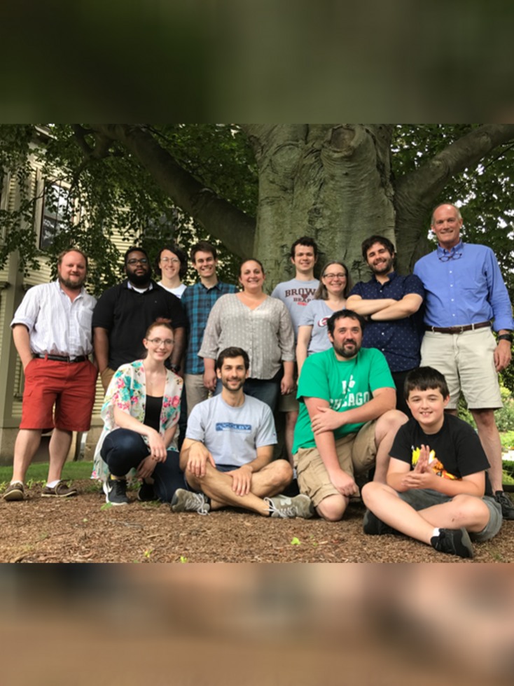 students posing with professor outside